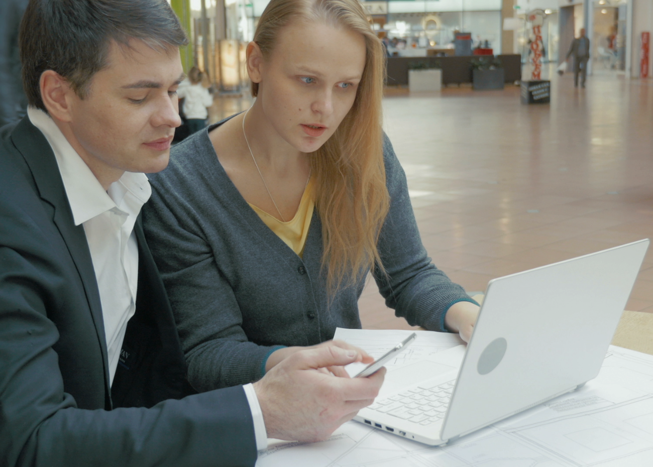Two people sitting closely togther looking at a laptop screen